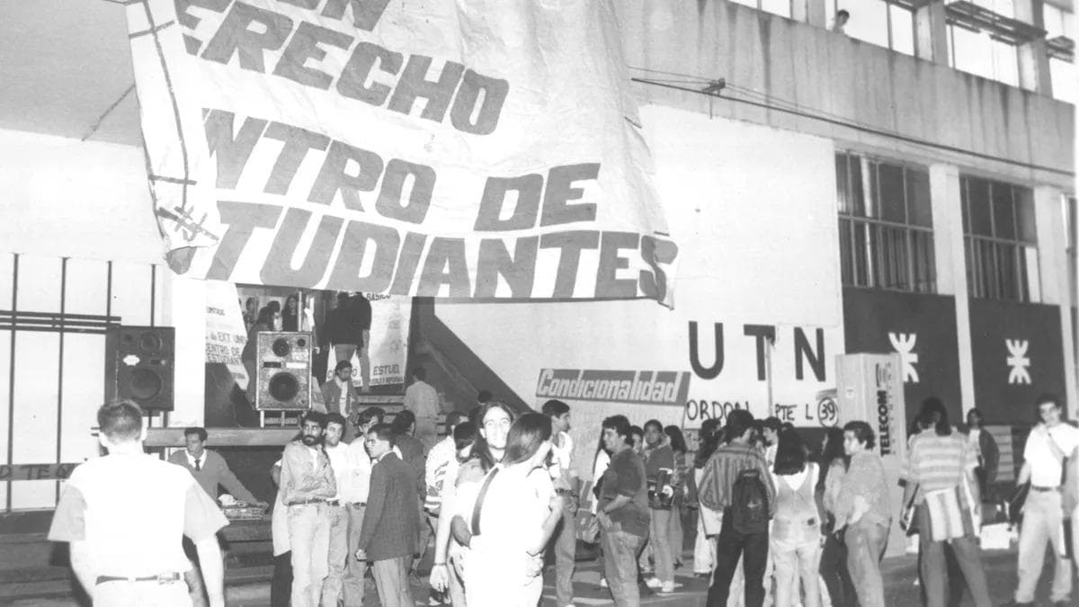 Estudiantes movilizados con una bandera del Centro de Estudiantes en la fachada de la UTN